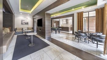 a rendering of a lobby with tables and chairs and a television at The Hendrix, Atlanta, Georgia